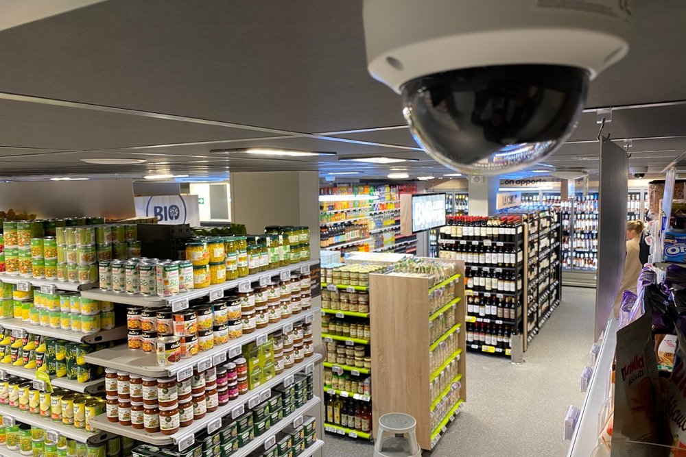 Caméra de vidéosurveillance installée à l'entrée d'un commerce avec panneau d'information visible